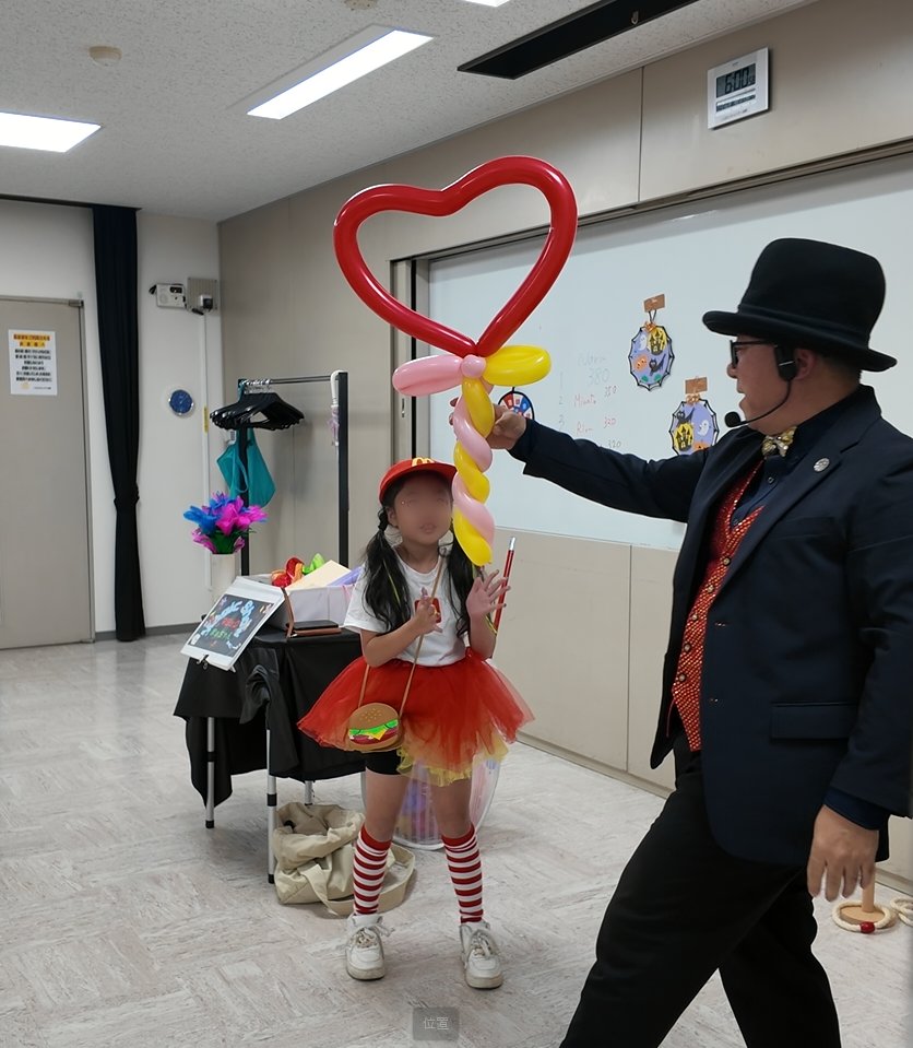 バルーンで作ったハートを子どもに手渡すマジックまぁちゃん